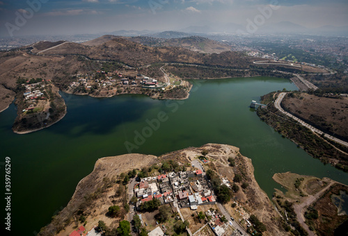 vista aérea de la presa Madin rodeada de zonas áridas, carretera y viviendas, al norte del valle de México photo