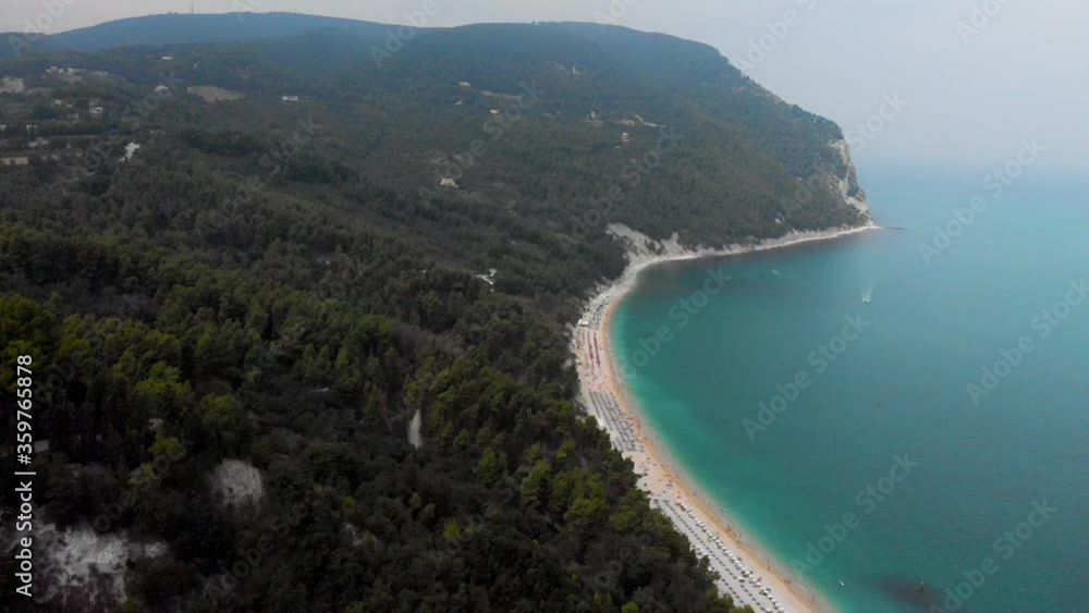 Drone Flying Over Magnificent Summer Mediterranean Sea Coast. Huge Italian Beach on the blue Ocean. Sirolo beach Italy. Drone Flying Over Magnificent Summer Mediterranean Sea Coast. Huge Italian Beach on the blue Ocean. Sirolo beach Italy.