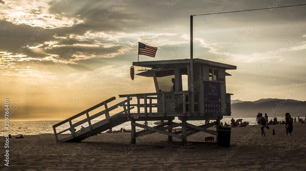 Silhouette of an iconic American beach lifeguard tower by sunset in California