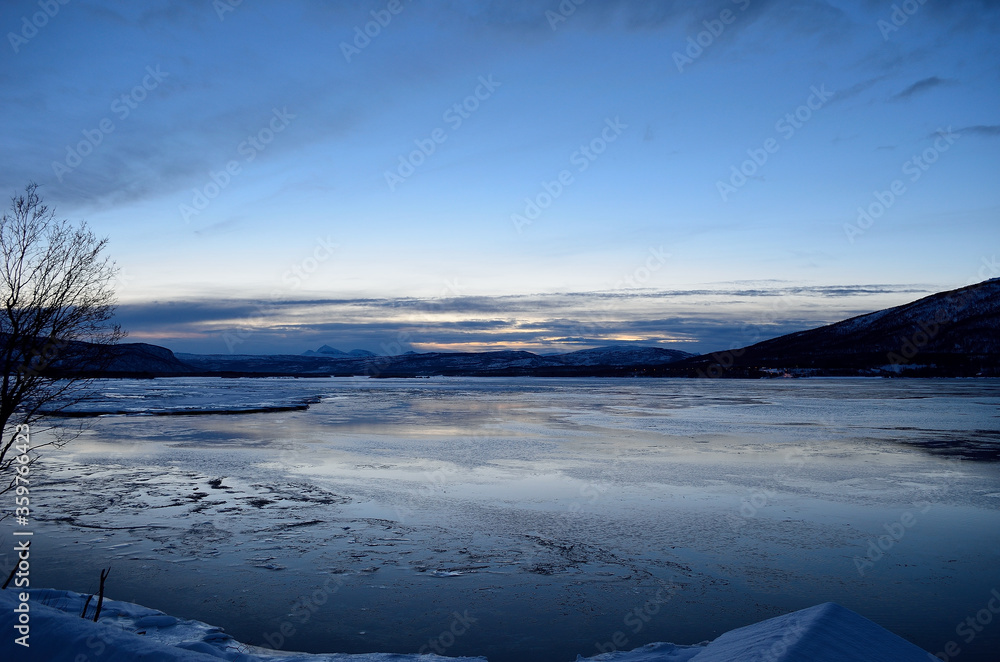 Obraz premium blue frozen fjord and snowy mountain during the blue hour in northern norway