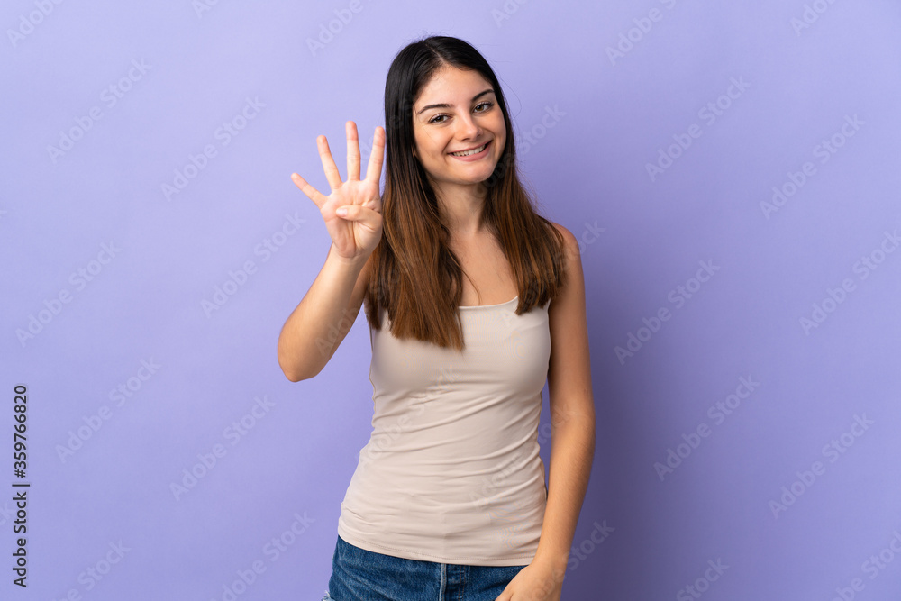 Young caucasian woman isolated on purple background happy and counting four with fingers