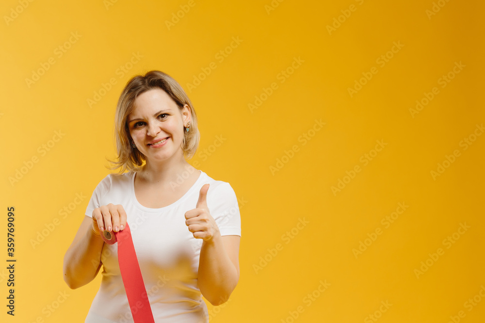 A therapist rolling kinesiology tape to demonstrate it on the yellow background. Alternative kinesio tape therapy, healthcare concept A therapist rolling kinesiology tape to demonstrate it on the yellow background. Alternative kinesio tape therapy, healthcare concept