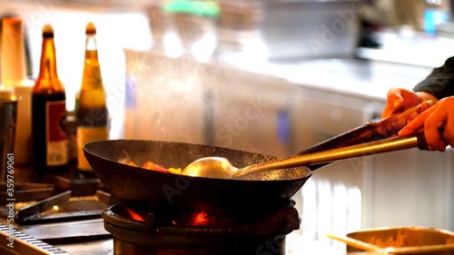 Photo of a man who is cooking in a wok