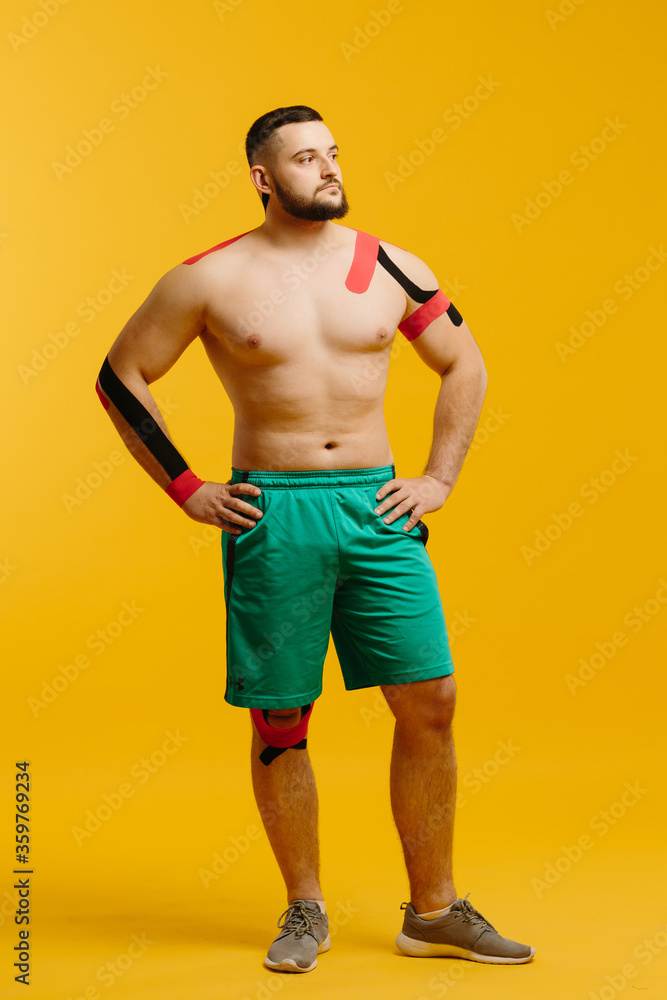 A professional athlete with kinesiology tape on arm and shoulder. Sport and rehabilitation, kinesiotherapy treatment