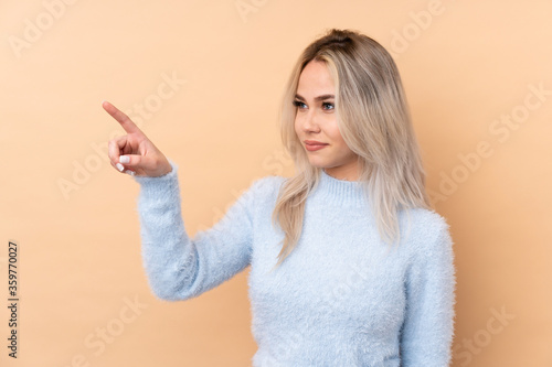 Teenager girl over isolated background touching on transparent screen