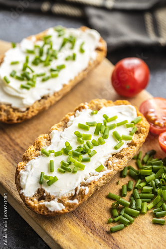 Crispbread with creamy cheese., green chive and tomatoes