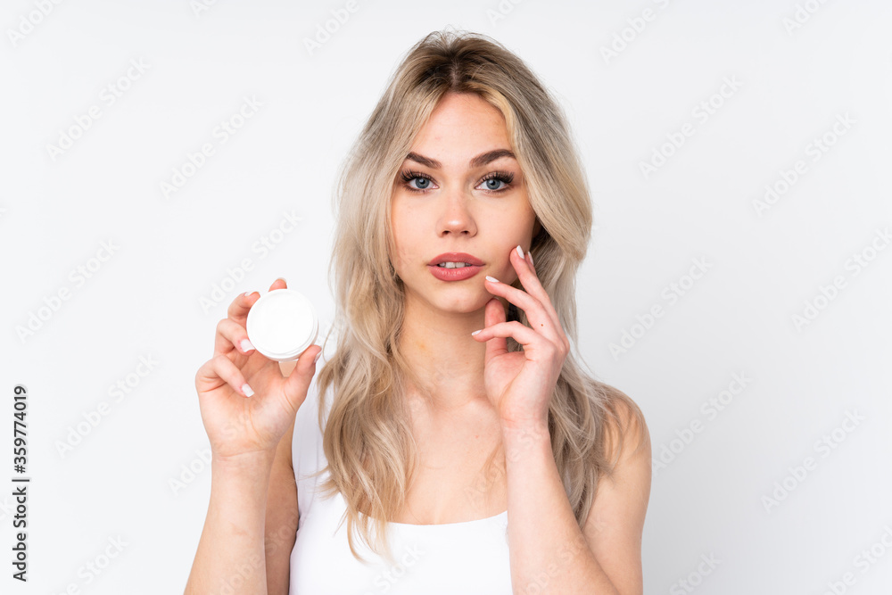 Teenager blonde girl over isolated white background with moisturizer Teenager blonde girl over isolated white background with moisturizer
