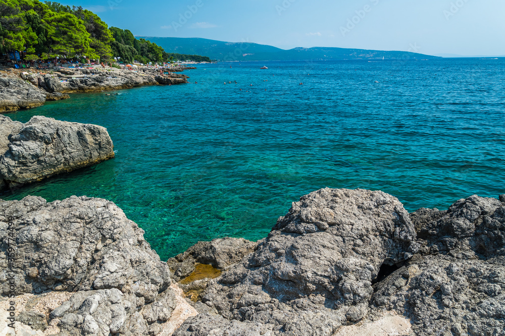 Amazing beach with stones and cliffs in Krk town. Krk town is a famous touristic destination on Krk island, Croatia. Space in right side