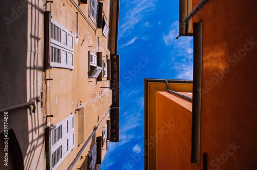 Photo of the sky between houses with a perspective to the top.