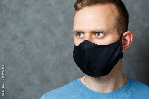 young guy man in black protective medical mask against viruses. COVID 19