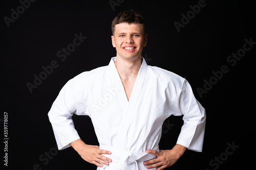 Young man doing karate over isolated black background