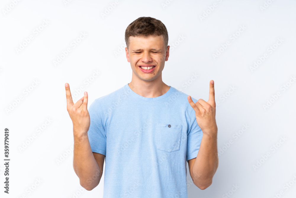 Young handsome man over isolated white background making rock gesture Young handsome man over isolated white background making rock gesture
