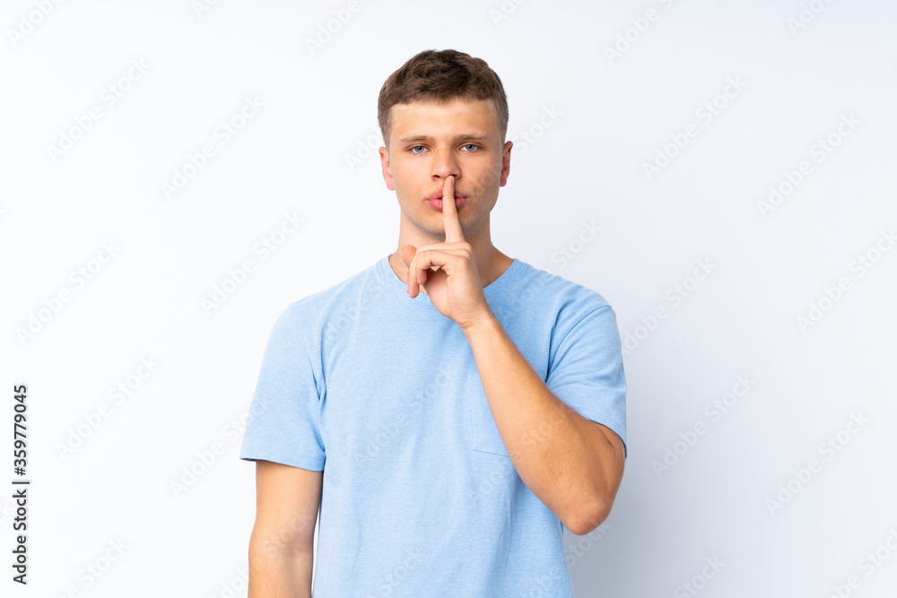 Young handsome man over isolated white background showing a sign of silence gesture putting finger in mouth Young handsome man over isolated white background showing a sign of silence gesture putting finger in mouth