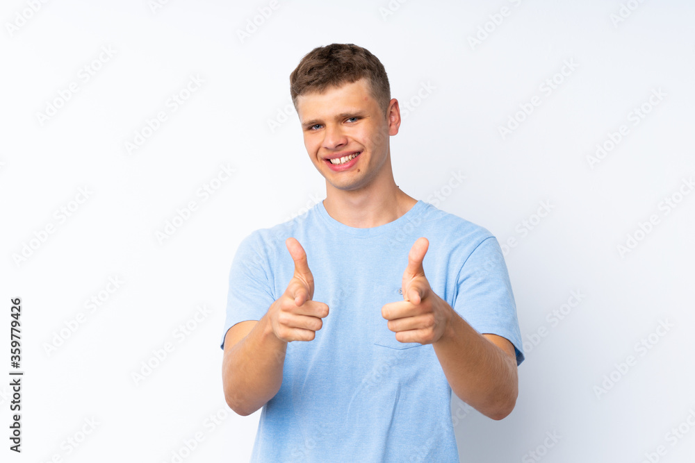 Young handsome man over isolated white background pointing to the front and smiling Young handsome man over isolated white background pointing to the front and smiling