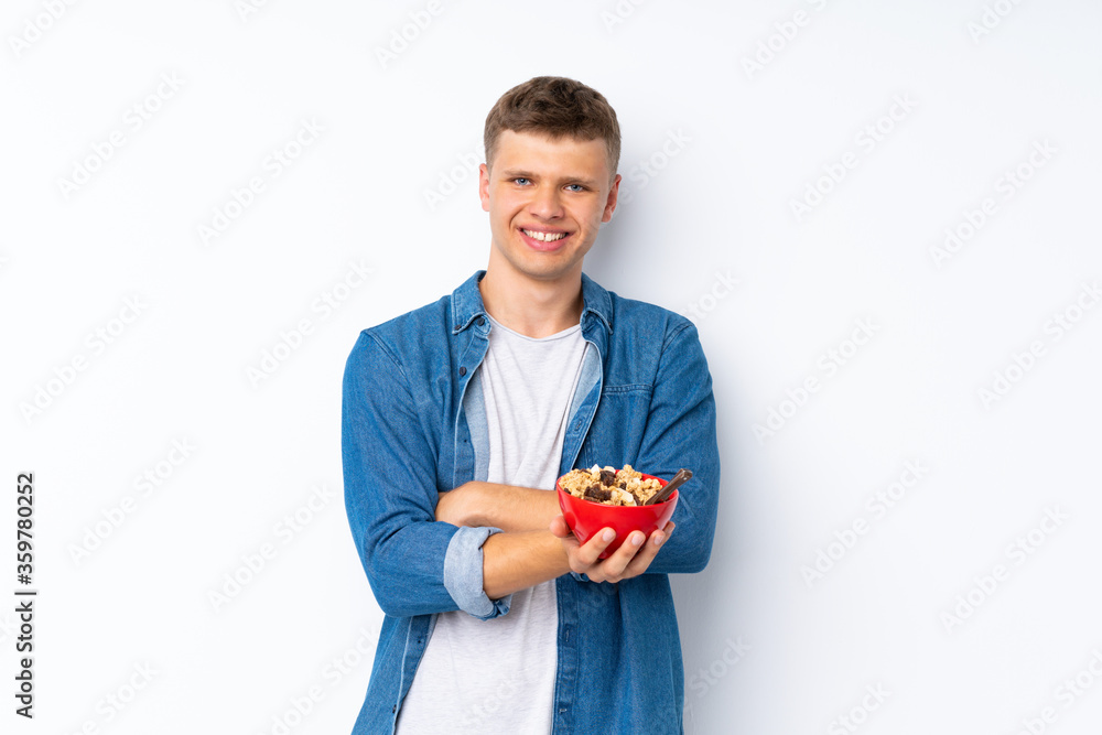 Young handsome man over isolated white background holding a bowl of cereals Young handsome man over isolated white background holding a bowl of cereals