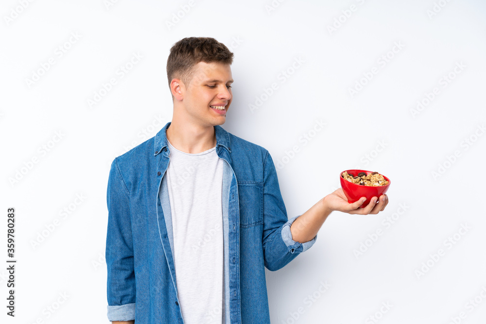 Young handsome man over isolated white background holding a bowl of cereals