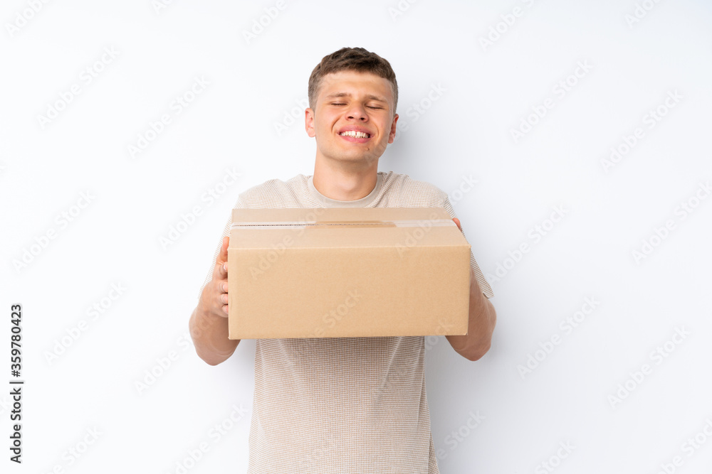 Young handsome man over isolated white background holding a box to move it to another site Young handsome man over isolated white background holding a box to move it to another site