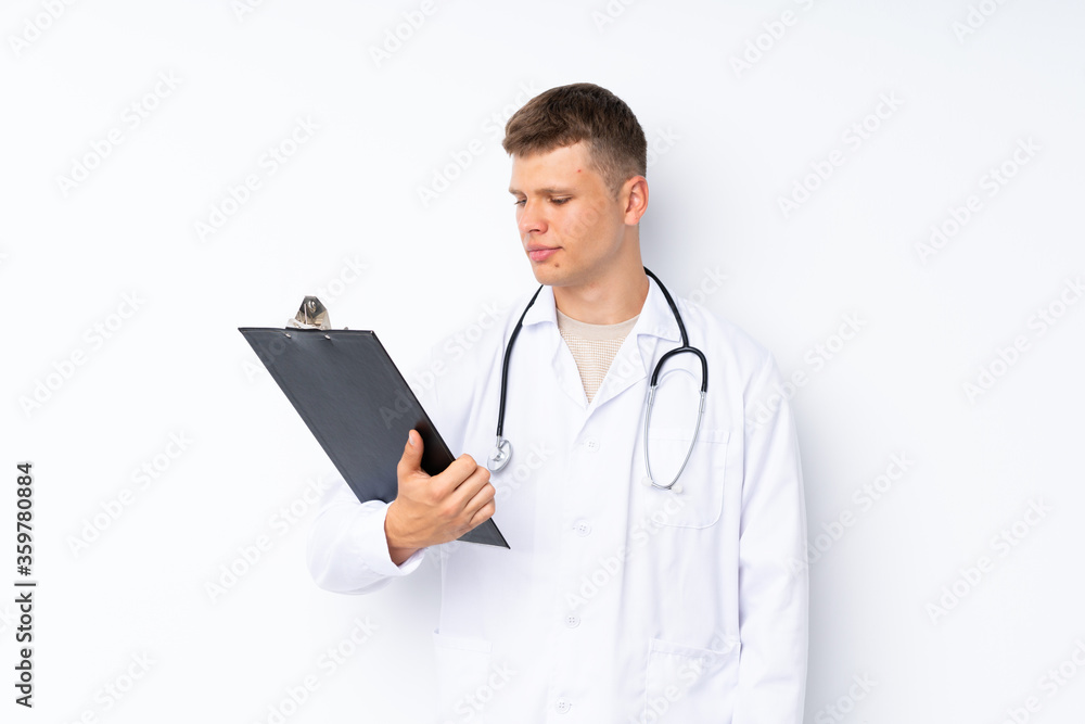 Young handsome man over isolated white background with doctor gown and holding a folder Young handsome man over isolated white background with doctor gown and holding a folder