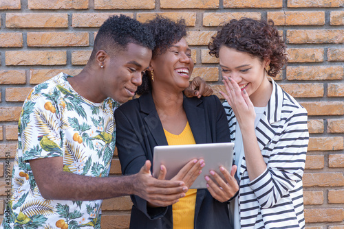 Group of young people laughing while using technology. photo