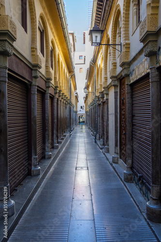 Perspective of the empty Ermita street in the Alcaiceria de Granada with all the shops closed