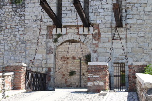 Stone wall with merlons and drawbridge gate of medieval castle of Brescia in north Italy photo