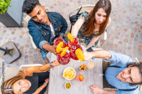 Friends drinking colored cocktail at outdoor bar