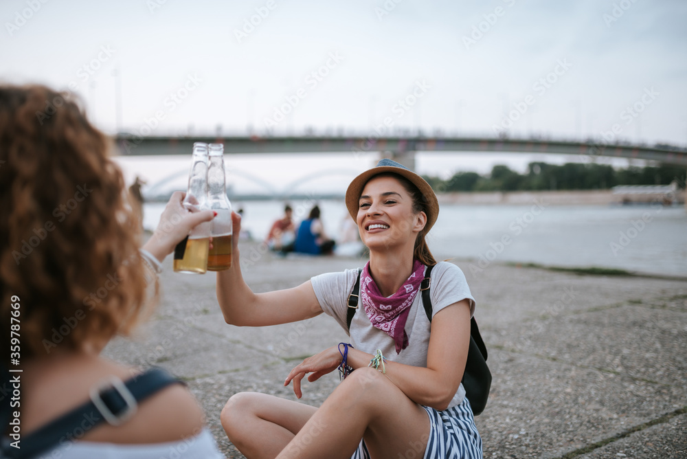 Two girls celebrating on the riverside in the city.
