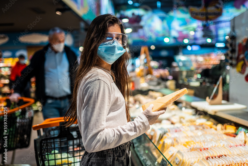 The girl with surgical mask is going to buy cheese.
