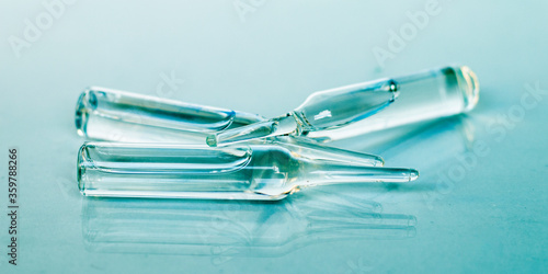 Medical ampoules close-up. Three glass ampoules on a blue background. Selective focus. Medical concept.