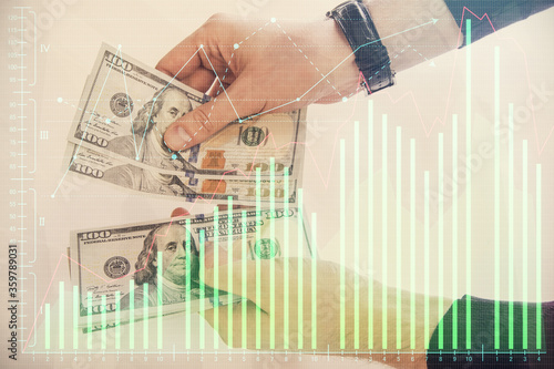 Multi exposure of financial graph drawing hologram and USA dollars bills and man hands. Analysis concept.