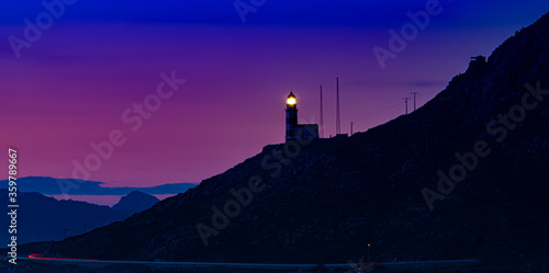 Wondeful red cloudy sky at sunset with lighthouse in the background in Galicia