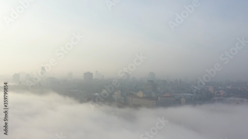 Aerial view of the city in the fog. © teksomolika