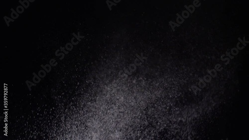 Water spraying droplets snow storm on a black background texture effect