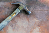 Old tool shows isolated hammer for construction on brown vintage texture background with copy space.