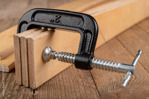 Carpentry clamp used for gluing wood. Carpentry accessories in a home workshop. photo