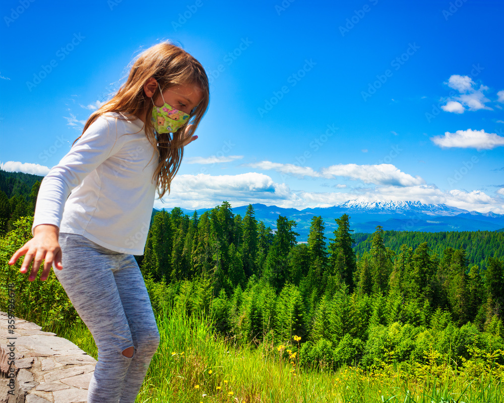 Young girl in mask playing in the mountains 