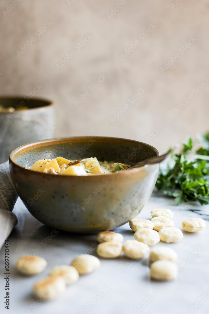 Potato, leek and bacon soup in a ceramic bowl with mini scones. Potato, leek and bacon soup in a ceramic bowl with mini scones.