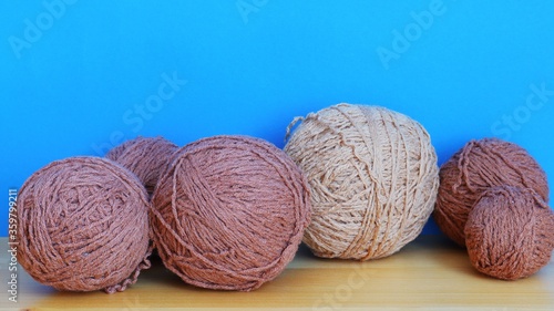 Skeins of brown woolen threads on a blue background close-up