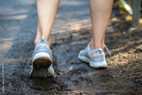 Athlete running through mud, outdoor running trail, joggers, exercise