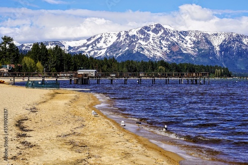 South shore Tahoe beach with snow capped mountains in the background