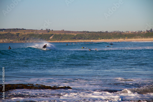 Surfer catching a wave at the beach on a bright sunny day