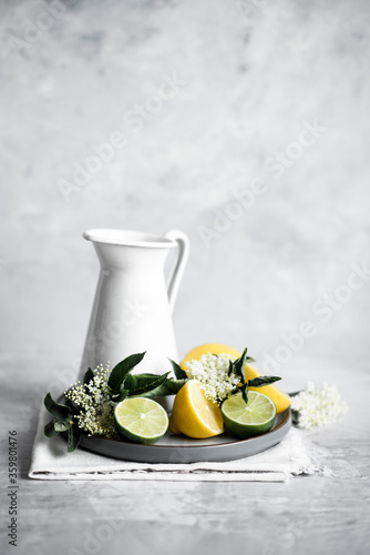 Elderflower cordial with lemon and lime on table photo