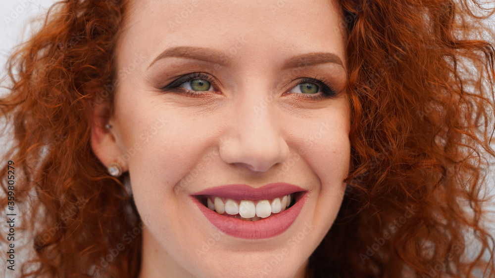 Closeup portrait on a whitish background beautiful girl with perfect teeth smiling, happy redhead model with nude make-up Closeup portrait on a whitish background beautiful girl with perfect teeth smiling, happy redhead model with nude make-up
