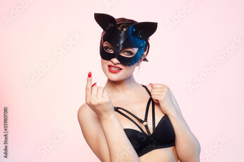 beautiful girl in a cat mask. playfully posing in front of the camera