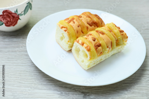 Close view of loaves of cheese bread on white plate on wooden table 