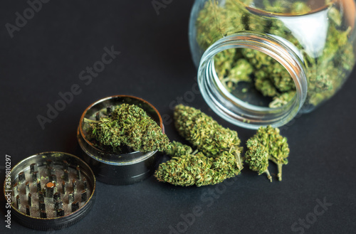 фотографія Medical Marijuana flower buds in glass jar and grinder