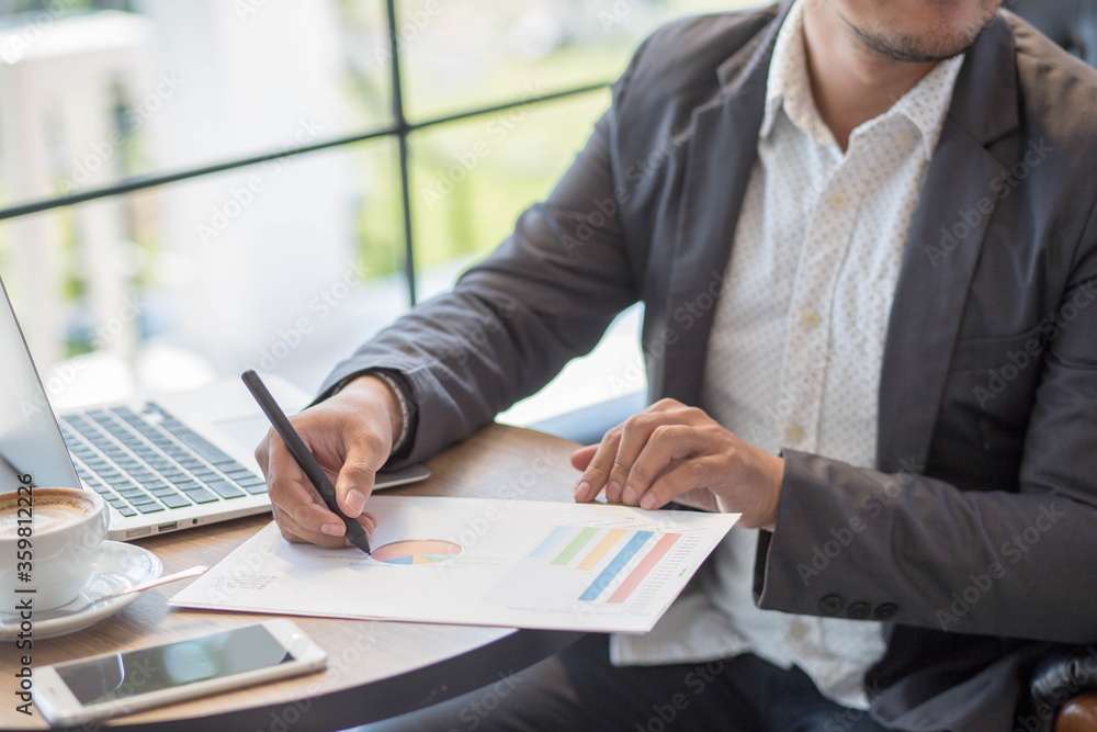 businessman working with documents,Close up hand holding pen writing on paper works.Business man working on wooden table. businessman working with documents,Close up hand holding pen writing on paper works.Business man working on wooden table.