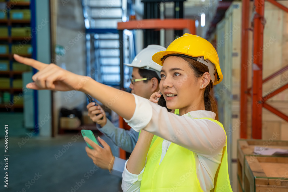 Worker working use radio to communicate in the large warehouse,Wholesale,Logistic,People and export concept. Worker working use radio to communicate in the large warehouse,Wholesale,Logistic,People and export concept.