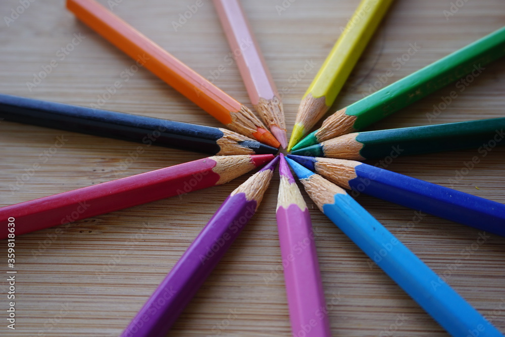 Naklejka premium circle center colored pencils on wooden table background. back to school concept