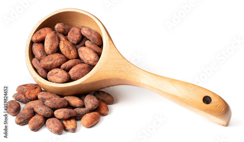 dried cocoa beans in the wooden spoon, isolated on white background